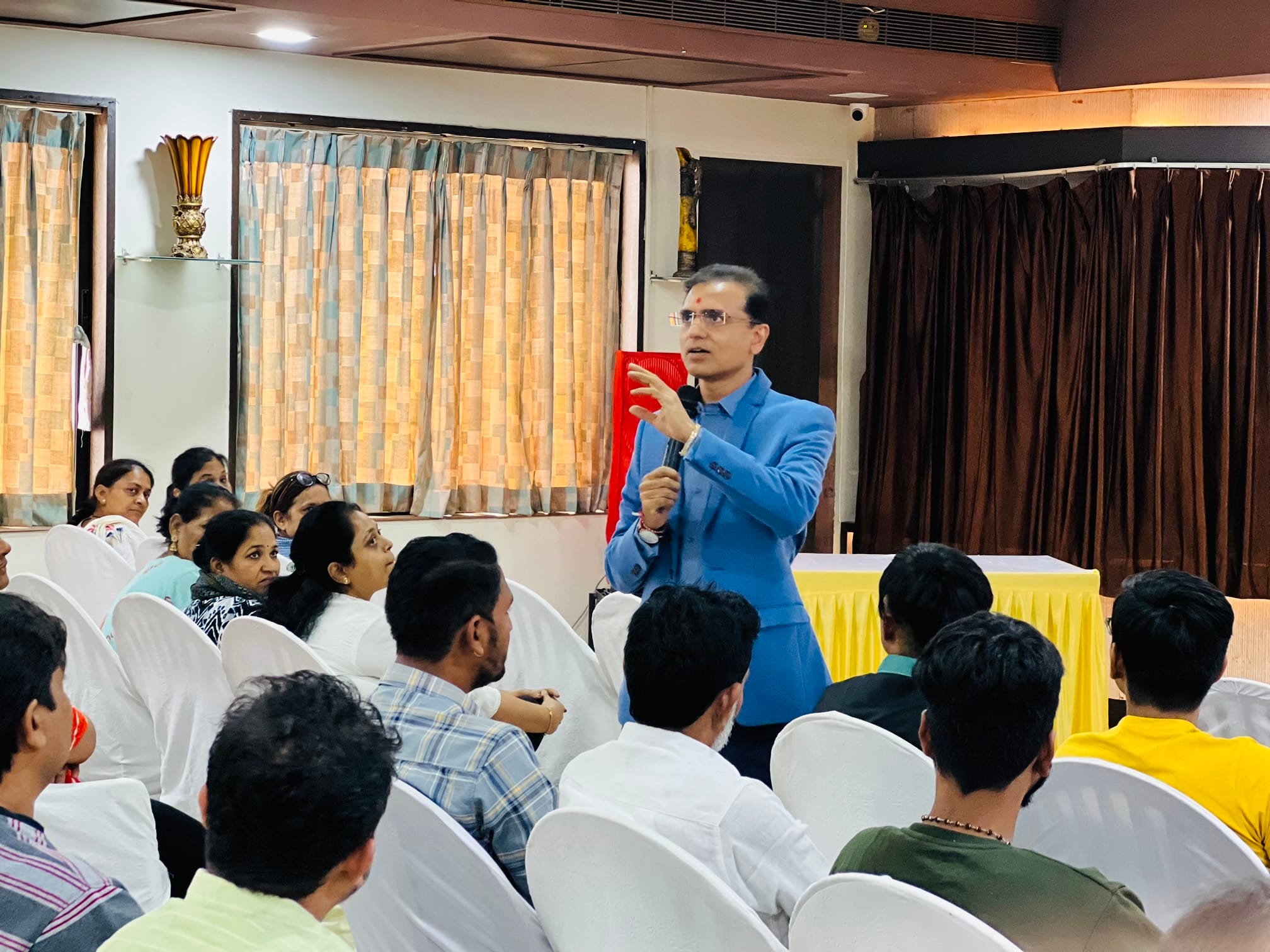 Amit Sarvaiya speaking to a seated audience at a community health talk